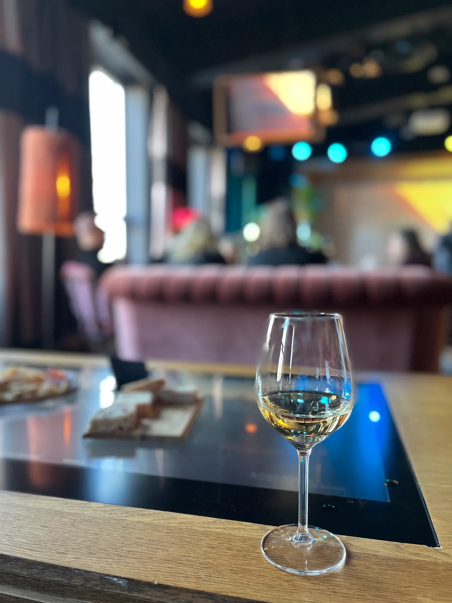 Glass of white wine in a cozy Estonian lounge with soft lighting